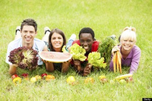 Teenagers in the park with different fruits and vegetables.